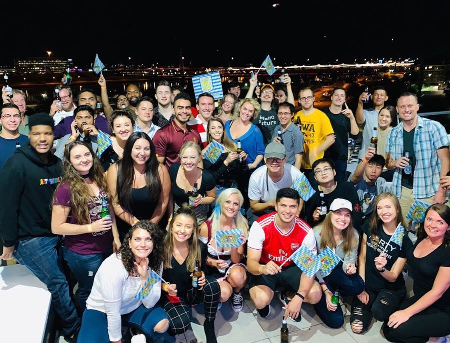 Residents at a rooftop night party overlooking Phoenix